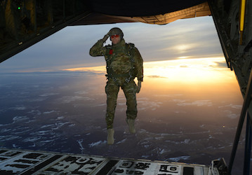 Soldier salutes while jumping out of aircraft embodying ideals of total force fitness   U S  Army photo by Visual Information