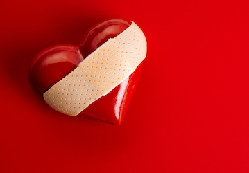 Bandage affixed to a red heart demonstrating the importance of mental health  good relationships  and total force fitness  