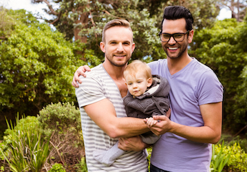 Gay couple holding their child between them experience positive well-being related to open communication about sexual identit