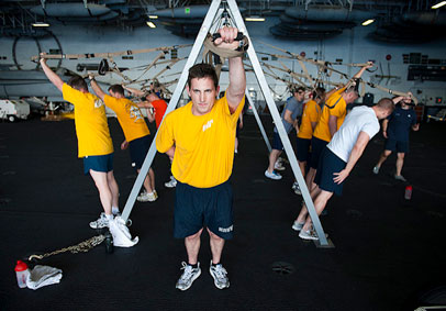 Sailors in group fitness class in hangar bay grow team resiliency and improve military performance   U S  Navy photo by Mass 
