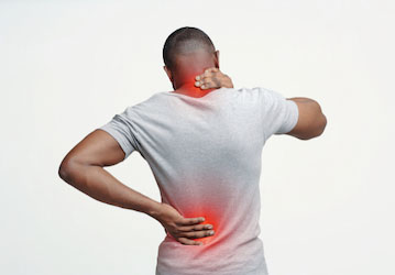 Individual grabbing back of neck and lower back in visible pain needs holistic training around injury prevention  