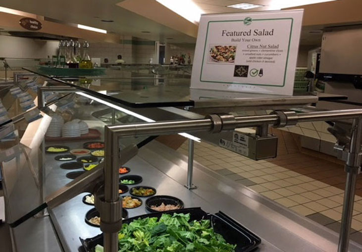 Salad bar with sign featuring a healthy option for a meal 