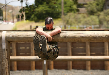 Uniformed Marine hanging on a log during a military workout enhances mental health and resilience   U S  Marine Photo by Sgt 