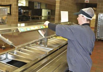 A dining facility employee checks Go 4 Green labels to promote nutrition-fueled performance    U S  Army Photo by Scott T  St
