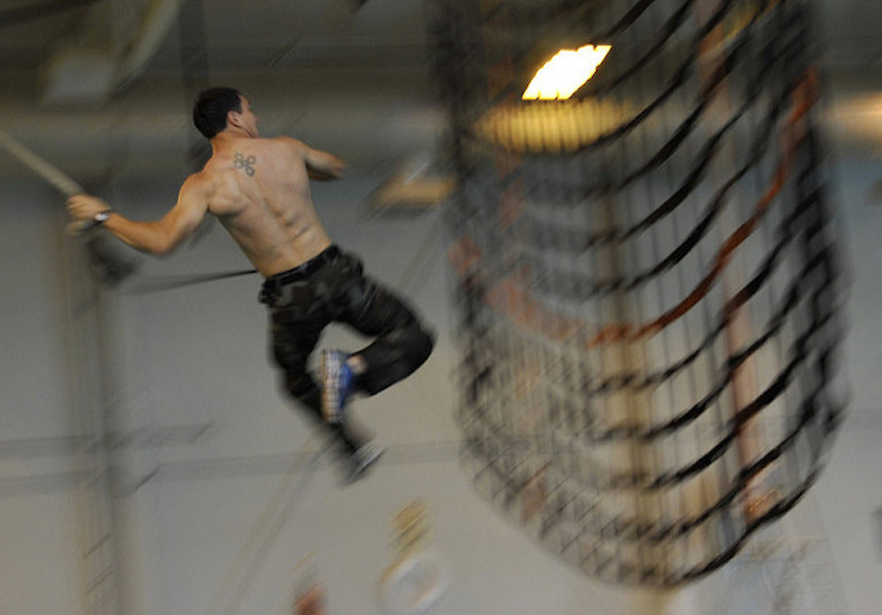 U S  Navy SEAL candidate swings to an cargo net during physical training improves military readiness   U S  Navy Photo by Mas