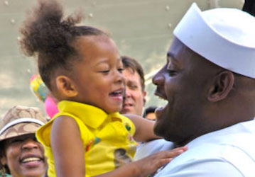 Sailor smiling and holding his small daughter showing family resiliency 