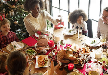 Family gather at the table to enjoy a healthy holiday meal that also supports weight management goals 