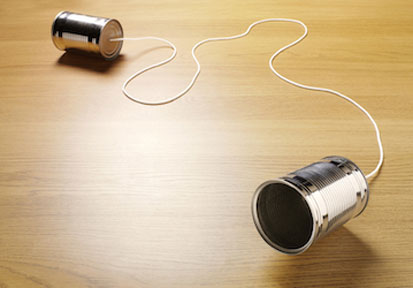 Two cans connected with string highlights assertive communication and active listening for strengthening relationships 