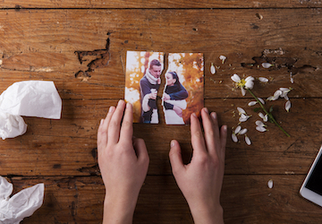 Hands holding a torn photo of a couple highlighting the importance of relationships and resilience  