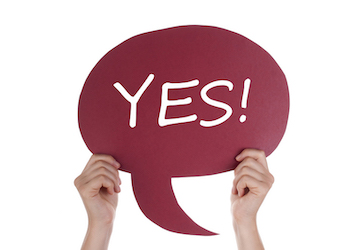 Hands holding a red speech bubble with the text "YES!" emphasizes the need for clear communication about sexual consent between romantic partners. 