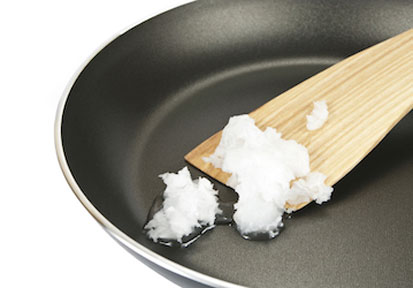 Service Member cooks coconut oil in moderation in a frying pan with a wooden spatula to improve performance nutrition and Tot