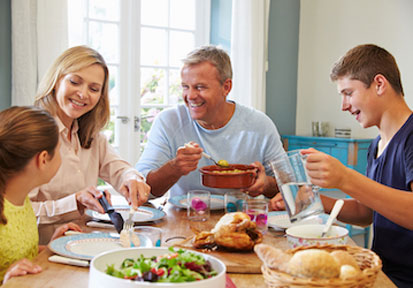 Family eating together at the kitchen table promotes quality time for building healthy habits and strengthening family relati