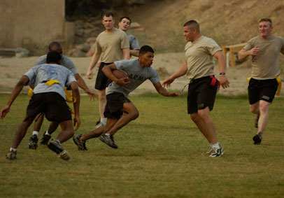 Group of soldiers in PT gear playing flag football highlighting their military fitness  total force fitness  and holistic hea