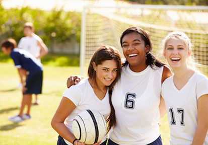 Three girls in soccer uniforms smiling and ready for practice after utilizing HPRC resources for performance nutrition