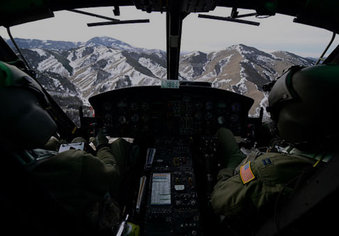 Helicopter pilots flying over mountainous  snowy terrain highlighting the need for total force fitness and performance optimi