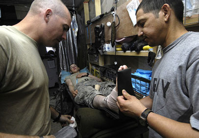 Two soldiers stabilizing injured ankle for another soldier highlights need for HPRC injury prevention strategies for peak mil