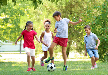 Kids having fun playing soccer outside display teamwork and stay healthy and fit through physical exercise  