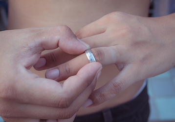 Person removing their wedding ring highlighting the importance of relationships  good communication  and holistic health  