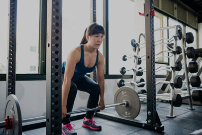Woman completes deadlift as part of military workout while preventing injury and achieving military wellness
