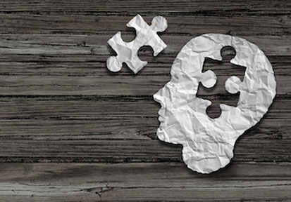 Head shaped piece of paper with puzzle piece cut out showing the importance of mental health and total force fitness 