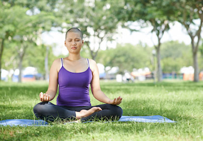 Woman practicing seated mediation outside manages stress and strengthens resilience to cope with breast cancer  