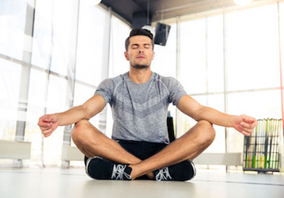 Man meditating practices mindfulness to improve mental health and optimize performance  