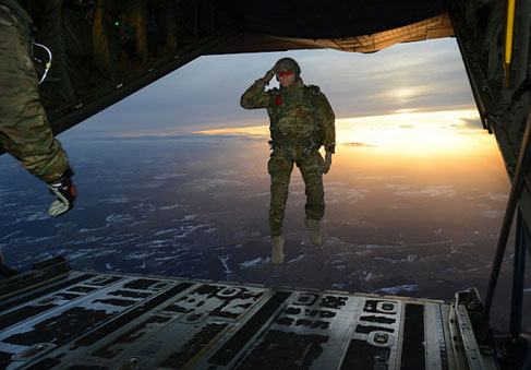A U S  Soldier salutes his fellow Service Members while jumping out of a C-130 Hercules aircraft during military exercise   U