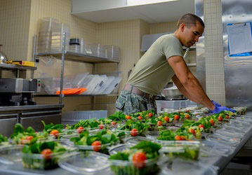 Service Member preparing salads as part of a performance nutrition menu in a military dining facility. (U.S. Air Force photo by Airman 1st Class Nathan Byrnes)
