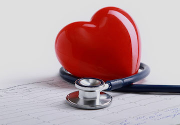 Red heart and stethoscope illustrate importance of performance nutrition and holistic stress management 