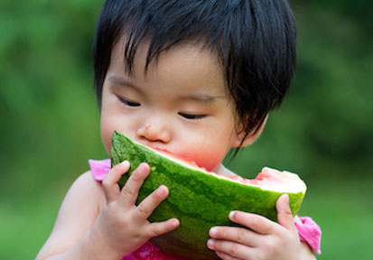 Young girl eating from a large piece of watermelon promotes nutritious foods for optimal health and development  