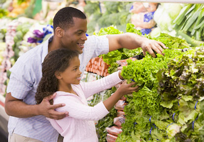 Father and daughter choosing lettuce in a produce section nurture a well-balanced diet for holistic wellness and healthy grow