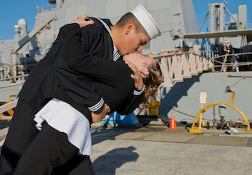 A Sailor kisses his wife to rekindle relationship after military deployment   U S  Navy photo by Mass Communication Specialis