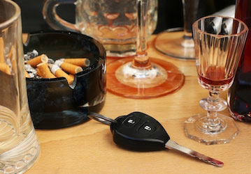 Full ashtray  empty alcohol glasses  car key stress risky behavior prevention for better health and wellness  