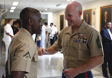 Marine Corps officer smiles at Lance Corporal during a discussion to show how friendly motivation builds teamwork and militar