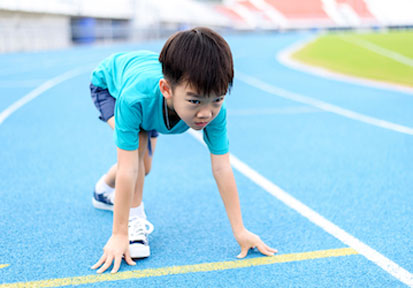 Young boy getting ready to run benefits from HPRC running strategies to optimize performance and prevent injury 