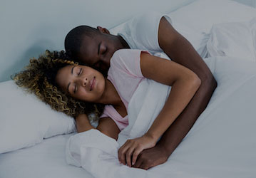 Couple sleeps peacefully in bed demonstrating link between quality of sleep and relationship satisfaction 