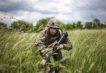 Marine patrolling grassy area displaying military fitness and optimized performance  U S  Marine Corps photo by 1st Lt  Hecto