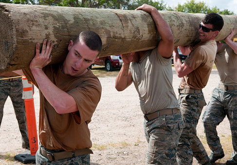 Group of airmen carrying heavy log together demonstrating teamwork and performance optimization   U S  Air Force photo by Air