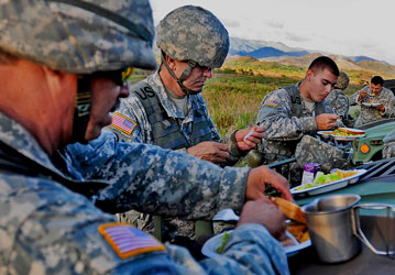 Soldiers eat dinner together in the field to promote team building  performance nutrition  and to optimize Total force fitnes