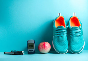 Blood glucose monitor  running shoes  and an apple showing items needed by diabetic for military workout 