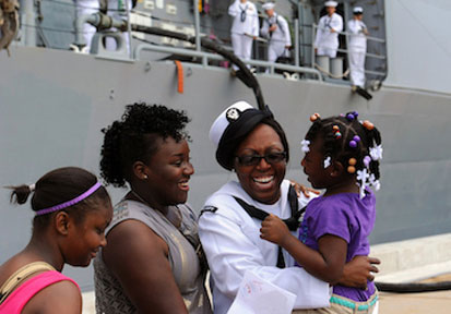 Sailor greets her family on the pier showing optimization of her relationships and military wellness which contribute to tota