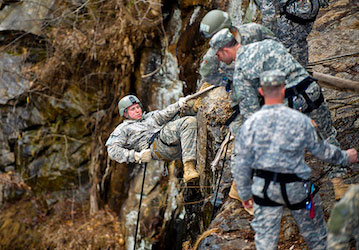 Group of soldiers practicing climbing on rocky  steep terrain to develop their military fitness  optimize performance  and to