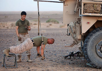 Marines working out using suspension straps on the back of a military vehicle the importance of military fitness and holistic