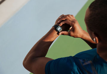 Man monitoring heart rate with a smartwatch during a military workout in order to optimize performance 