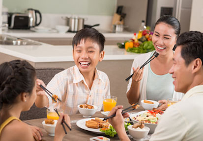 Family gathered around dinner table talking and eating strengthen their relationships with communication and quality time  