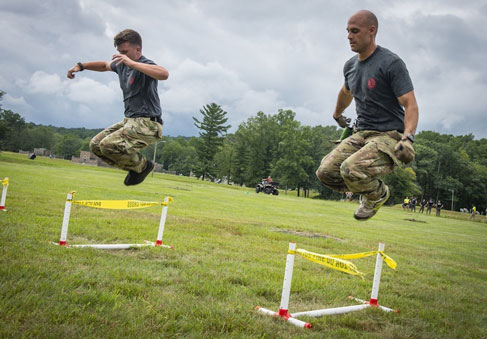 Airmen perform a plyometric exercise over hurdles during physical training. Photo by Tech. Sgt. Steven Tucker