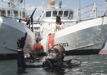 U S  Coast Guard in diving gear in the water pointing up uses visual signals for optimal military communication  U S  Coast G