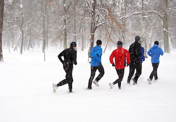 People running in snow safely train and modify their physical exercise routine with injury prevention practices. 