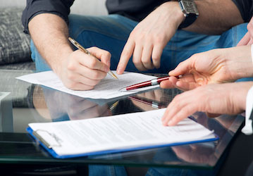 Closeup of two people s hands reviewing POA documents stresses military deployment readiness through communication and legal 