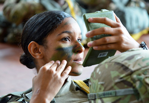 Paratrooper puts the finishing touches to her face paint camouflage during training to optimize performance   U S  Army Photo